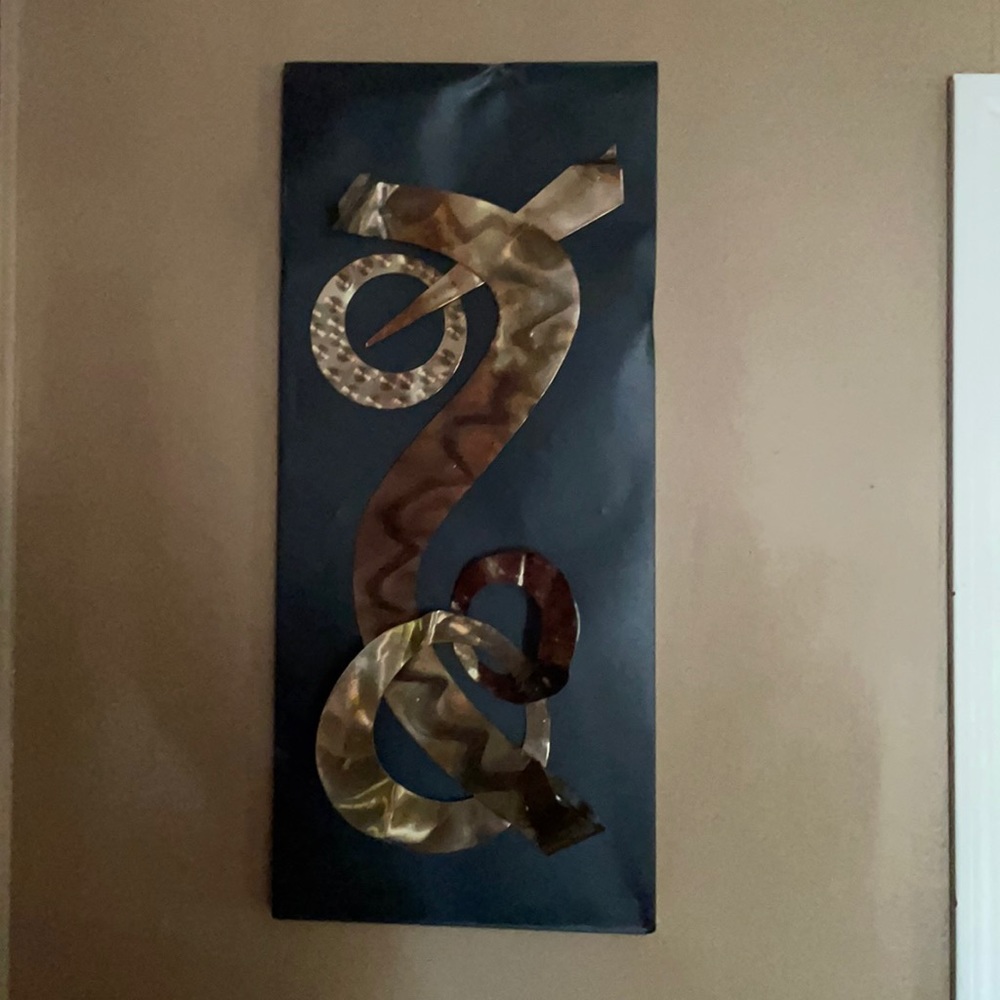 A metal art hanging piece with all different shapes, sizes, and colors.